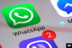FILE - The WhatsApp icon is shown on a smartphone.