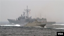 台灣海軍“光華-6”型導彈快艇（前）在高雄附近海域舉行的演習期間從一艘佩里級護衛艦旁駛過。（2013年1月22日）