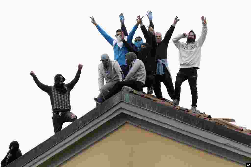 Prisoners hold a protest against new rules to deal with the coronavirus, including the suspension of family visits, on the roof of the San Vittore prison in Milan, Italy.