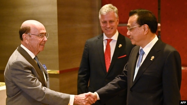 美国商务部长罗斯(左)在泰国首都曼谷出席东盟会议期间与中国总理李克强(右)握手(2019年11月4日)。
