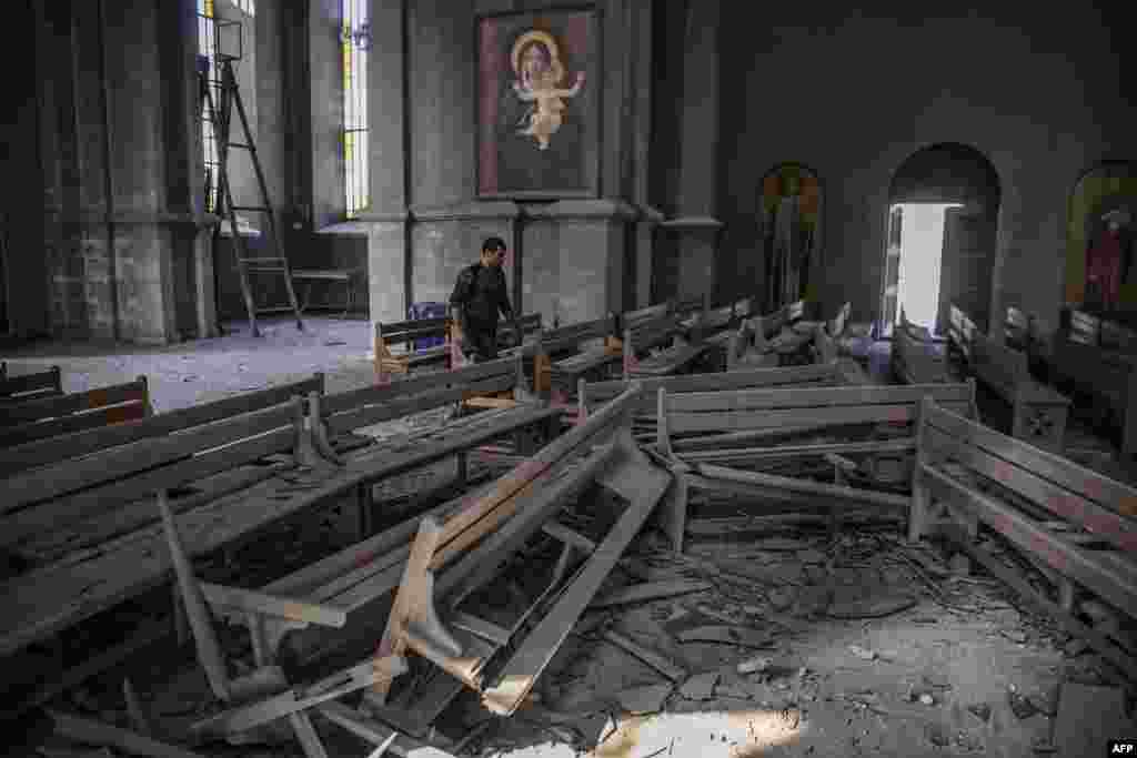 A man walks in rubbles inside the Ghazanchetsots (Holy Saviour) Cathedral in the historic city of Shusha, that was hit by a bomb as hostilities between Armenian and Azerbaijani continues over the disputed Nagorno-Karabakh province.