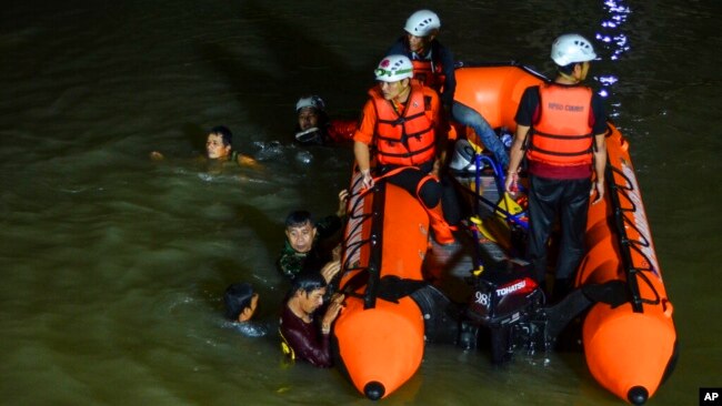 Rescuers search for drowning victims in a river in Ciamis, West Java, Indonesia, Oct. 15, 2021.