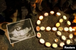 A photo of music icon John Lennon and peace sign made of candles sit on the pavement near Lennon's star during a gathering of fans and supporters in front of the Capitol Records building on the Hollywood Walk of Fame in Hollywood, California December 8, 2005.