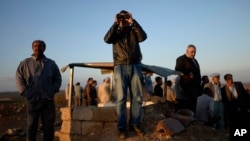 Turkish Kurds watch clashes between Syrian Kurdish fighters and Islamic State militants close to the Turkey-Syria border near Suruc, Turkey, Sept. 28, 2014. 