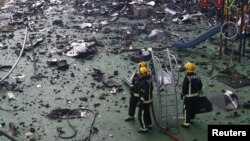 消防队员清扫因火灾而掉下来的残骸(2017年6月15日)