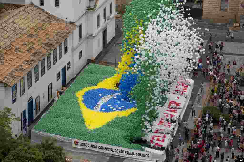 Members of Sao Paulo&#39;s Commerce Association release thousands of balloons with the color of the Brazilian flag to celebrate the end of the year in downtown Sao Paulo, Brazil. 