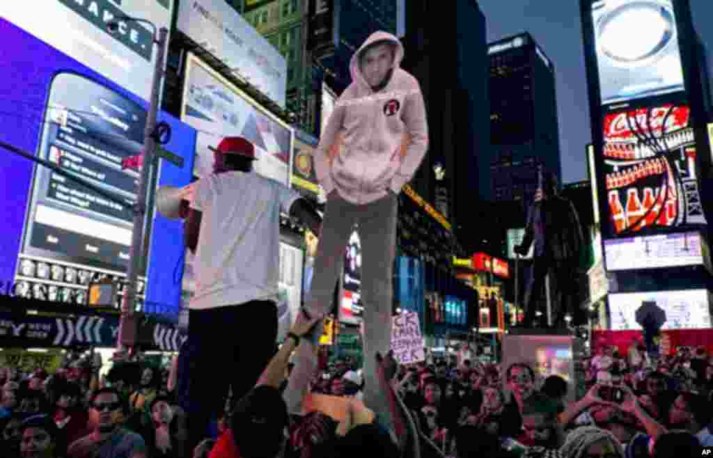 Người biểu tình ở Quảng trường Times, New York, với bìa cắt hình thiếu niên Trayvon Martin.