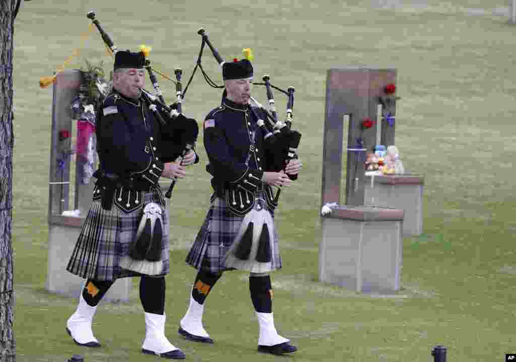 Bagpipers walk through the Field of Empty Chairs at the Oklahoma City National Memorial at the start of ceremonies to commemorate the 20 year anniversary of the Oklahoma City bombing in Oklahoma City, April 19, 2015.