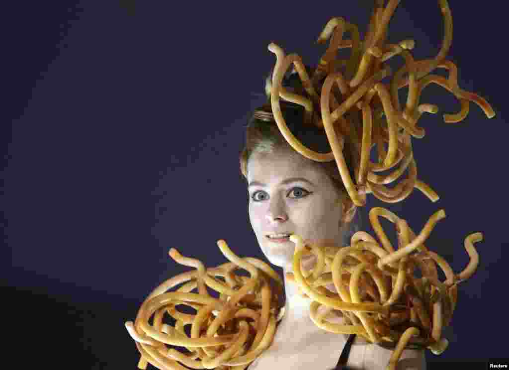 A woman with pieces of cheese on her head and shoulders is seen at the international exhibition of food and food technology in Minsk, Belarus.