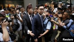 香港民族党召集人陈浩天在香港外国记者会演讲后离开时被媒体记者包围。 （2018年8月14日）