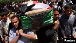 Residents carry a coffin during the funeral of an Iraqi soldier in Baghdad, April 25, 2013.