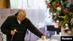 Seorang pria memberikan suaranya dalam pemilu sela di Tokyo, 14 Desember 2014.