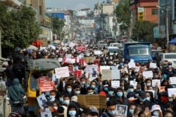 People take part in a demonstration against the February 1 military coup, along a street in the town of Muse in Shan state, near the China-Myanmar border on February 8, 2021. (Photo by STR / AFP)