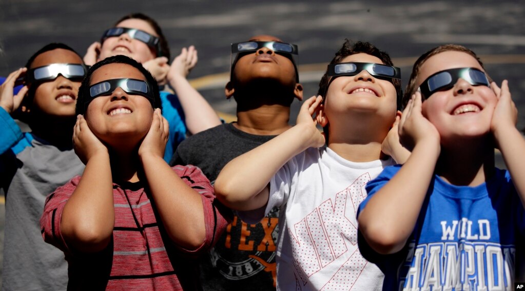 گروهی با عینک های مخصوص سرگرم تماشای خورشید گرفتگی در آمریکا.