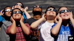 Fourth graders at Clardy Elementary School in Kansas City, Missouri, practice the proper use of their eclipse glasses in anticipation of Monday's solar eclipse, Aug. 18, 2017.