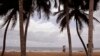 FILE: Woman carry goods for sale near a fishing village renowned as a tourist hot spot visited by French and other tourist yearly in Grand Bassam, Ivory Coast, Tuesday, Oct. 27, 2015. Ivory Coast has halted fishing to help depleted stocks replenish., hurting the industry.
