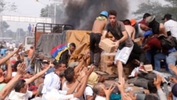 VENEZUELA – People try to take part of the humanitarian aid from a truck that was set on fire in Ureña, on 23 February 2019.