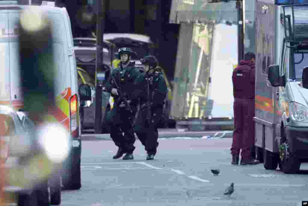 Armed British police officers walk within a cordoned off area after an attack at the London Bridge, June 4, 2017.