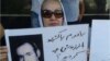 خانم راحمی پور در پلاکاردی به عدم پاسخ حکومت به کشتن برادرش معترض است. 