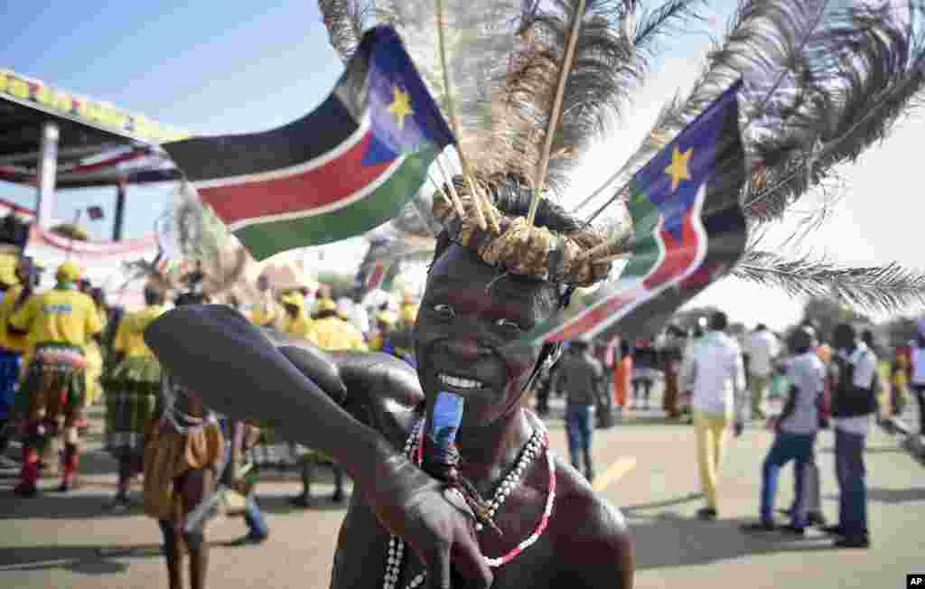 A South Sudanese man wears a headdress of feathers and the national flag, as he attends an independence day ceremony in the capital Juba, South Sudan. South Sudan marked four years of independence from Sudan, but the celebrations were tempered by concerns about ongoing violence and the threat of famine.