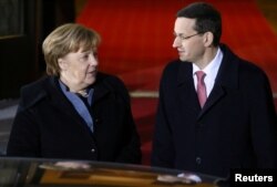 Poland's Prime Minister Mateusz Morawiecki welcomes Germany's Chancellor Angela Merkel at the Chancellery of the Prime Minister in Warsaw, Poland, March 19, 2018.