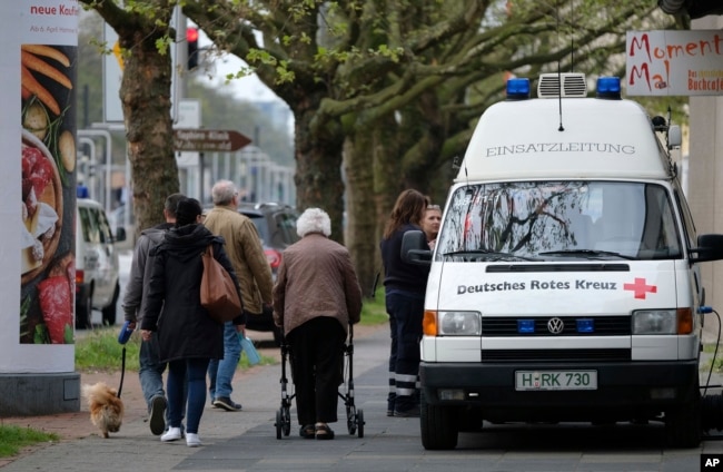 Residents pass by rescue workers in Hannover, northern Germany, May 7, 2017 when 50,000 people have to leave their homes when an unexploded World War II-era bomb is defused.