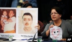 Irma Carrillo of Phoenix holds up a hand-drawn picture of her heart with two holes in it for her two children who have been missing since 1999, as she speaks during a hearing held by the Inter-American Commission on Human Rights, Oct. 5, 2018, at the University Colorado in Boulder, Colo.