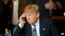 FILE - Donald Trump, at the time still the Republican presidential candidate, is seen using his mobile phone during a stop in North Charleston, South Carolina, Feb. 18, 2016.