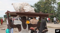 Un jeune homme porte ses affaires sur sa tête à Bujumbura, capitale du Burundi, le 7 novembre 2015. (AP Photo)