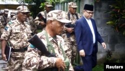 Murad Ebrahim, chairman of the Moro National Liberation Front, walks with his security group before the start of anews conference inside their camp at Sultan Kudarat in Maguindanao province, southern Philippines, September 5, 2011. 