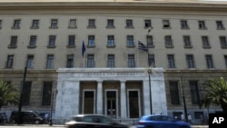 Athenians drive their cars in front of the Central Bank of Greece building in central Athens on Monday, July 25, 2011.