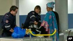 FILE - Custom officers check the luggage of a passenger at Charles de Gaulle airport, in Roissy, north of Paris, March 23, 2016.