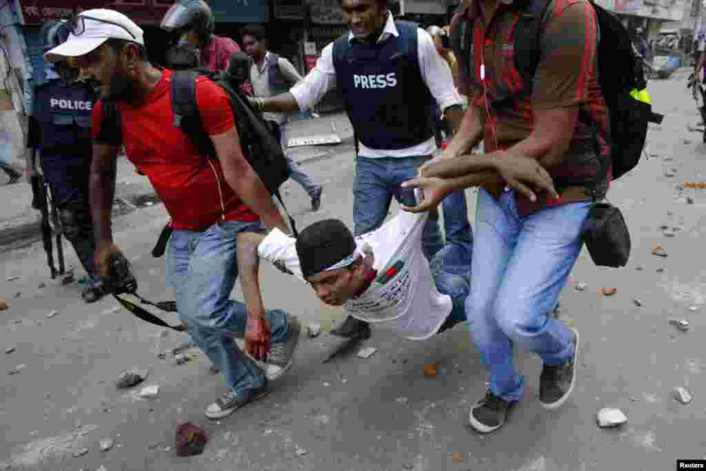 Members of the media rescue assist an injured activist of Hifazat-e-Islam during a clash with police in front of the national mosque in Dhaka May 5, 2013.