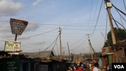 Wires are seen interwoven above the houses, connecting house to house in Kibera, Kenya. The maze of wires makes it difficult to tell the legal connections from the illegal ones. (R. Ombuor/VOA)