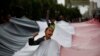 A boy chants slogans through a gap in a national flag raised by Shiite rebels, known as Houthis, during a protest against Saudi-led airstrikes in Sanaa, Yemen, April 15, 2016. 