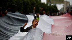 Un petit garçon portant le drapeau des rebelles shiites Houthis a Sanaa, le 15 avril 2015.