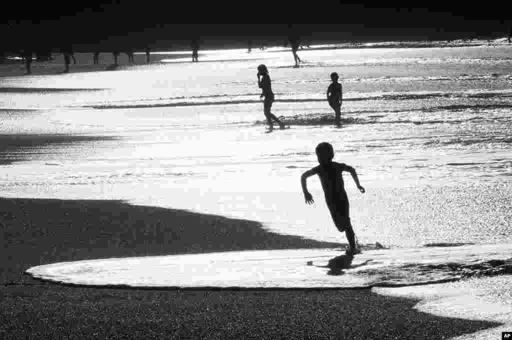 Warga Perancis menikmati udara yang hangat di pantai kota Biarritz, Perancis barat daya.