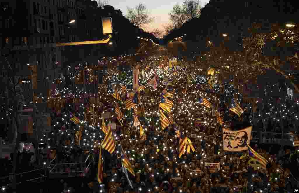 Pro-independence demonstrators march waving independence flags, during a demonstration supporting the imprisoned pro-independence political leaders in Barcelona, Spain, Feb. 16, 2019.