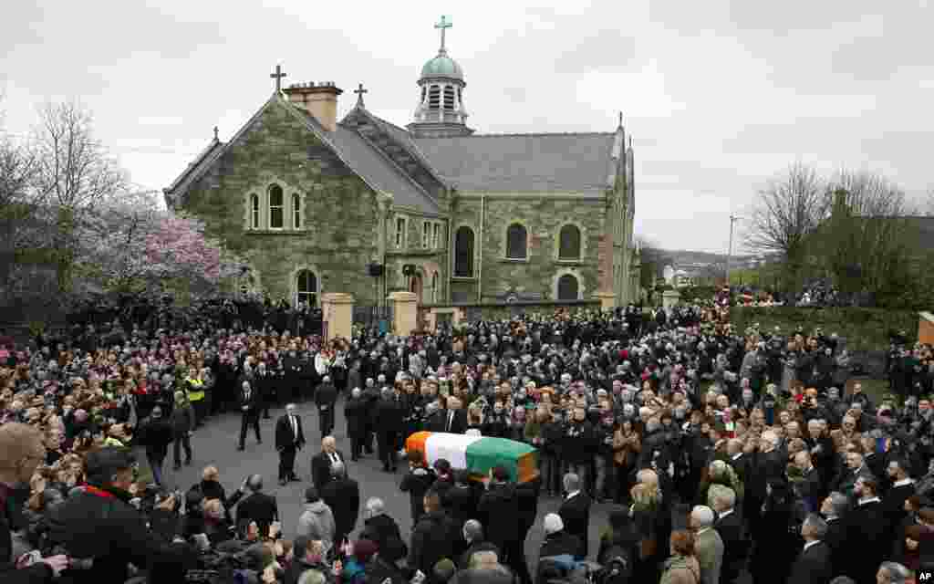 The coffin of former Irish Republican Army commander and Sinn Fein deputy leader Martin McGuinness is carried toward St. Columba&#39;s Church in Londonderry, Northern Ireland.