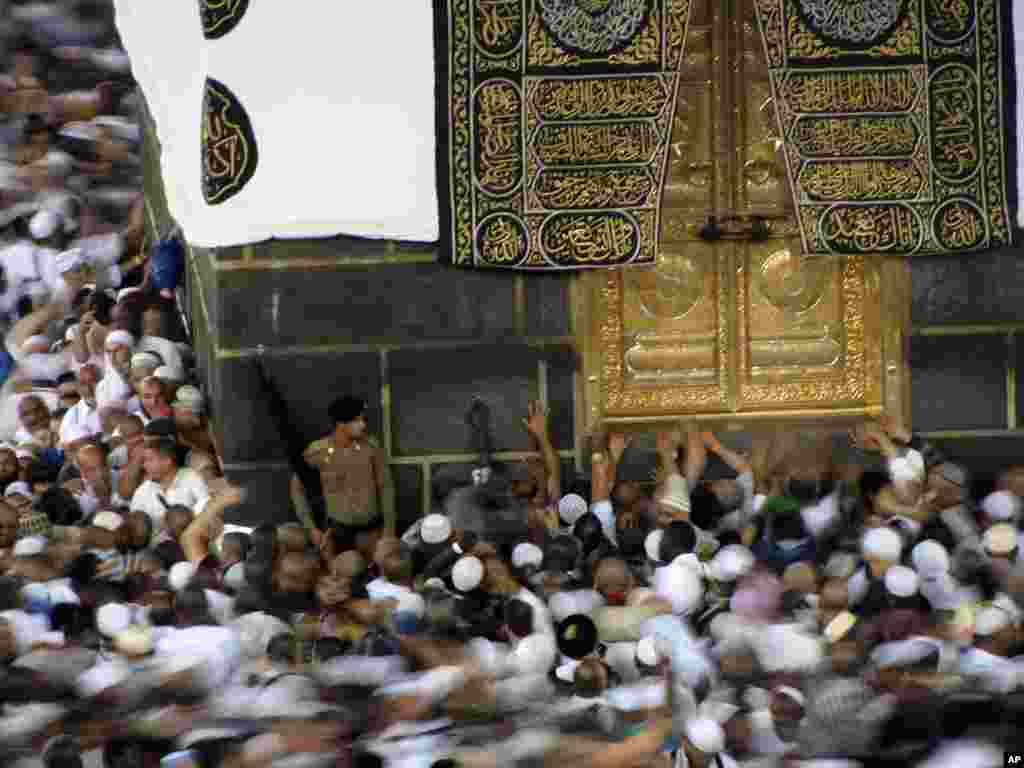 Mahujaji wakigusa mlango wa dhahabu wa jengo la pembe nne la Kaaba katika msikiti mtukufu wa Makka, Agosti 07, 2019, kabla ya ibada ya Hijja.(AP Photo/Amr Nabil)