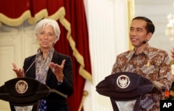 Managing Director of the International Monetary Fund Christine Lagarde, left, holds a joint news conference with Indonesian President Joko Widodo, right, at the Presidential Palace in Jakarta , Indonesia, Sept. 1,2015.