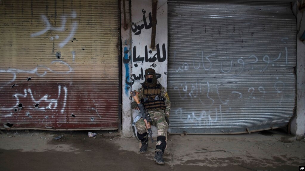 A Iraqi soldier sits in a neighborhood recently retaken by Iraqi security forces during fights with Islamic State militants on the western side of Mosul, Iraq, March 23, 2017.