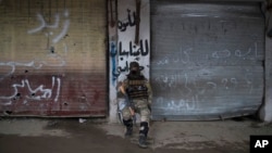 A Iraqi soldier sits in a neighborhood recently retaken by Iraqi security forces during fights with Islamic State militants on the western side of Mosul, Iraq, March 23, 2017.