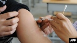 FILE - A Chinese nurse inoculates a man at a hospital in Hefei, east China's Anhui province, Nov. 10, 2009. China has vowed to tighten its regulation of locally-made vaccines to ensure their usefulness, after a recent scandal exposed regulatory loopholes.