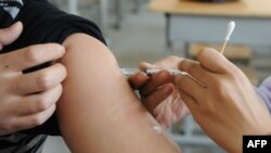 FILE - A Chinese nurse inoculates a man at a hospital in Hefei, east China's Anhui province, Nov. 10, 2009.