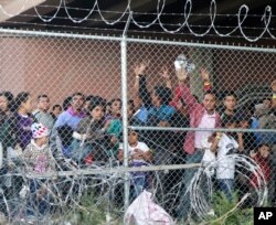 Central American migrants wait for food in El Paso, Texas, March 27, 2019, in a pen erected by U.S. Customs and Border Protection to process a surge of migrant families and unaccompanied minors.