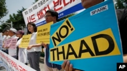South Korean protesters hold signs during a rally to denounce deploying the Terminal High-Altitude Area Defense, or THAAD, in front of Defense Ministry in Seoul, South Korea, July 8, 2016.