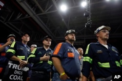 Coal miners listen as President Donald Trump speaks during a rally, Aug. 21, 2018, in Charleston, W.Va.