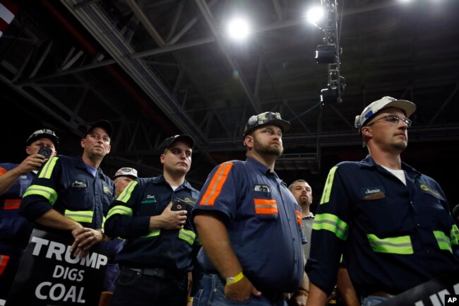 Coal miners listen as President Donald Trump speaks during a rally, Aug. 21, 2018, in Charleston, W.Va.