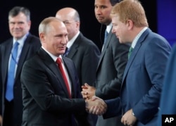 Russia's President Vladimir Putin (left) shakes hands with Myron Brilliant, executive vice president and head of International Affairs at the U.S. Chamber of Commerce, at the St. Petersburg International Economic Forum in St. Petersburg, Russia, June 2, 2017.